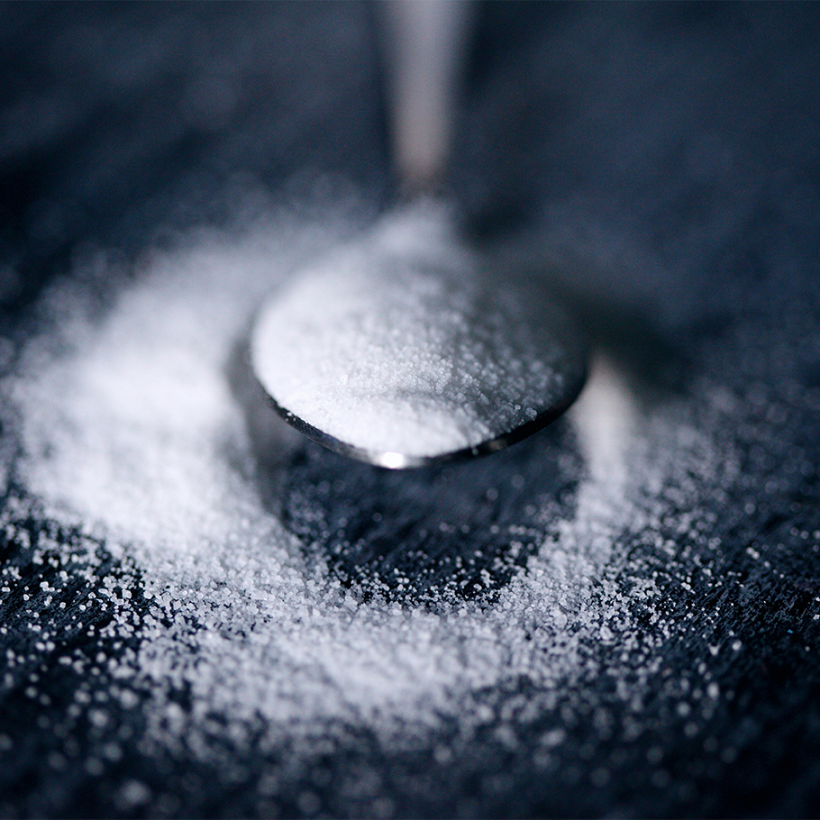 Spoon resting in scattered white sugar