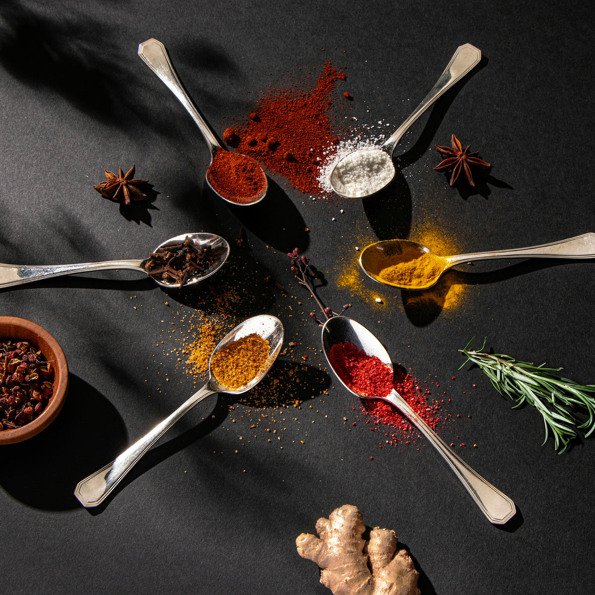 Spoons of colorful ground spices with star anise and ginger