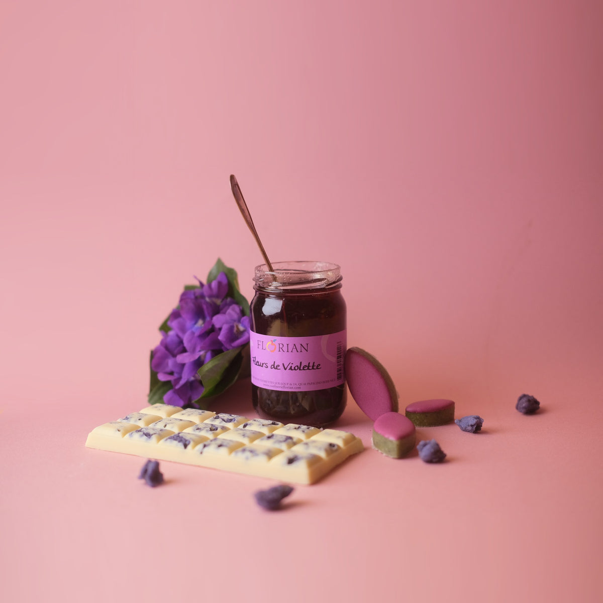 Confiserie Florian violet flower jelly jar with fresh violets and white chocolate on a pink background