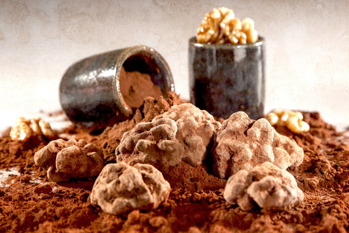 Noix au chocolat poudrées de cacao du Domaine de Béquignol à côté de deux petits pots en terre cuite