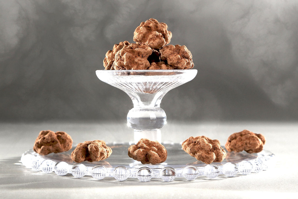 Noix enrobées de chocolat du Domaine de Béquignol servies sur un présentoir à gâteaux en verre
