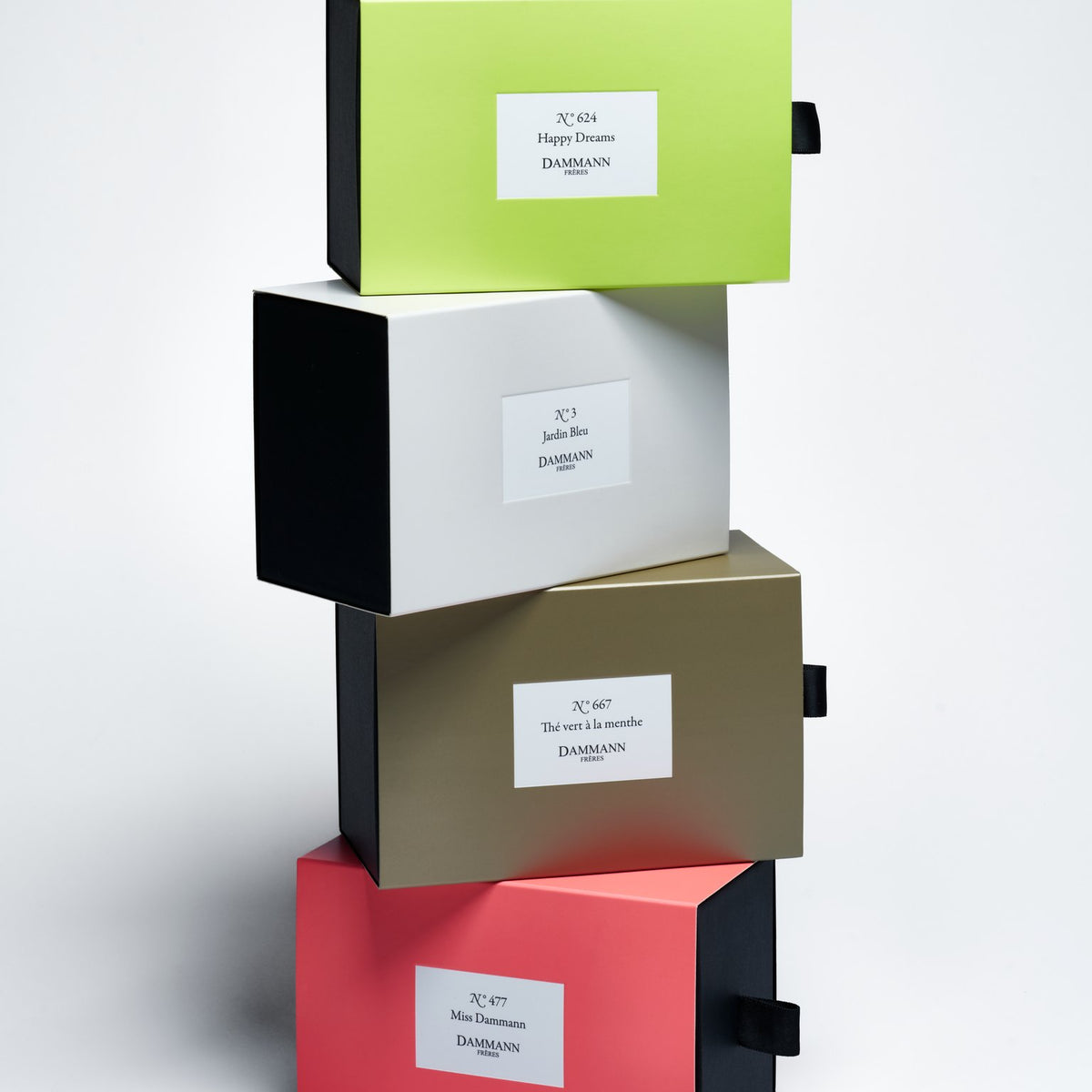 Stack of Dammann Frères drawer gift boxes with the pink N°477 Miss Dammann box at the bottom