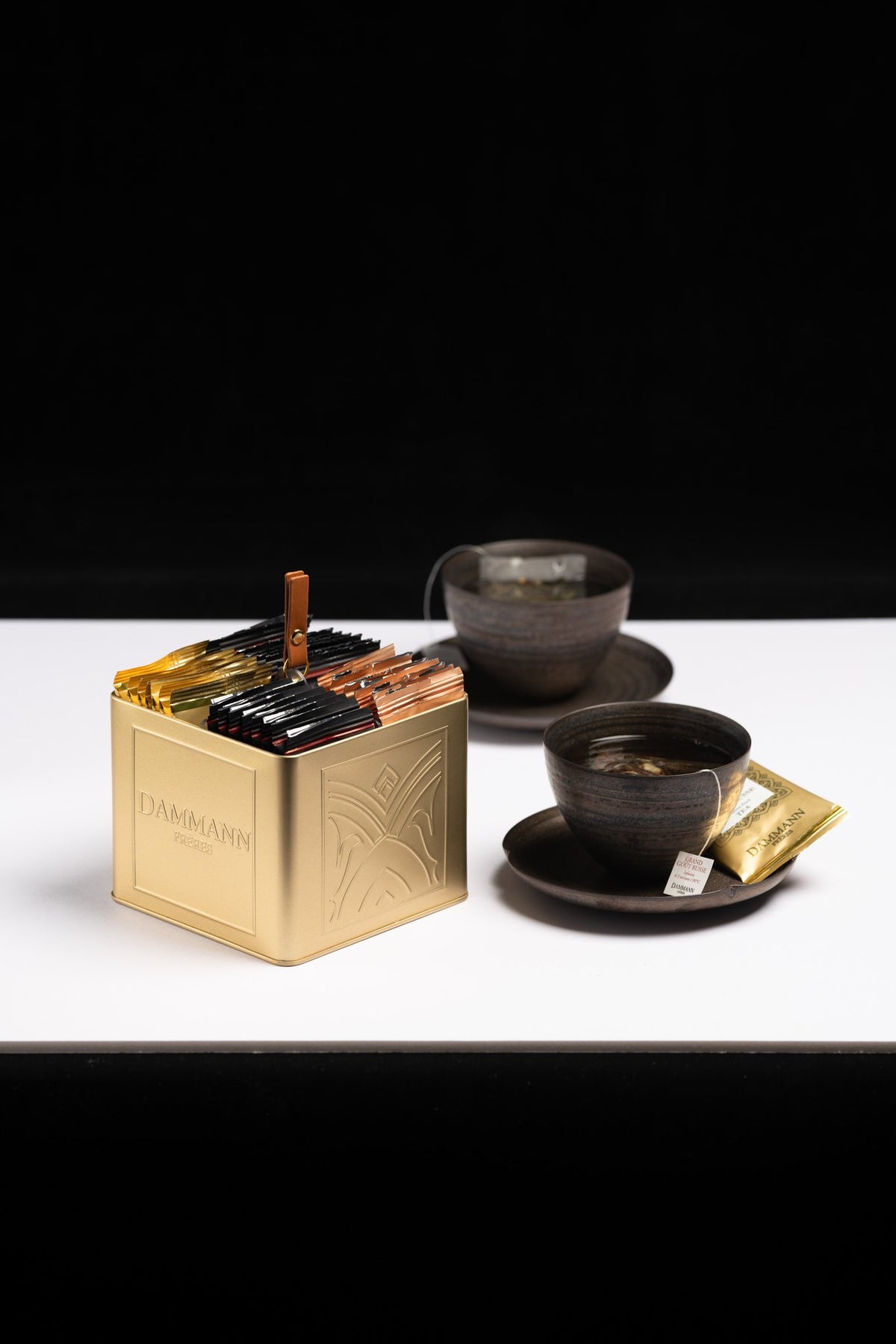 Boîte à thé dorée Infiniment de Dammann Frères avec des tasses