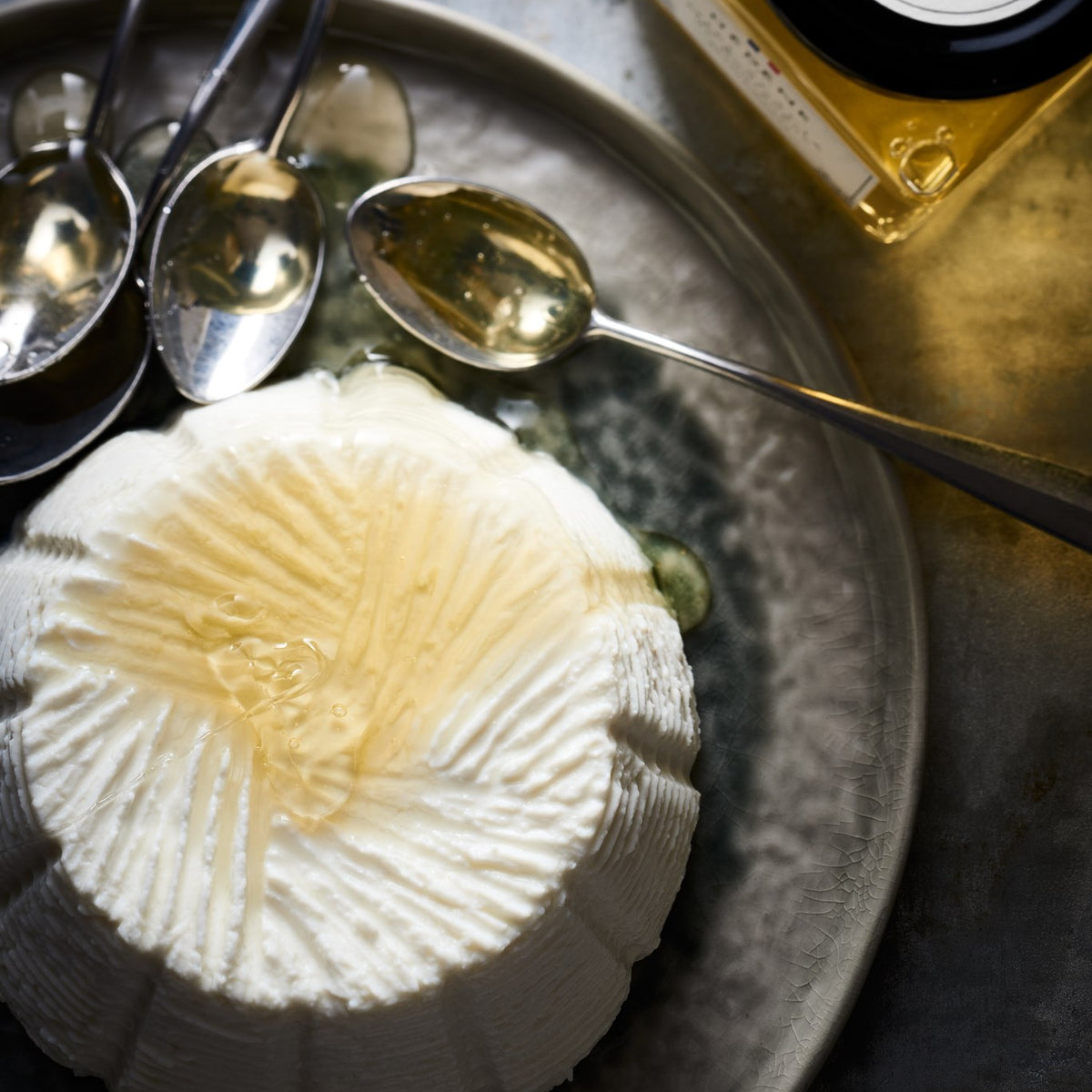 Miel d’acacia Hédène avec du brocciu et des cuillères en argent