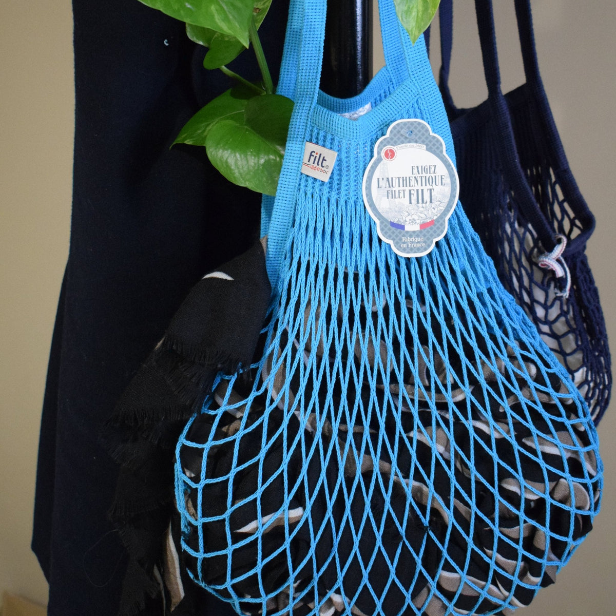 Blue Joyau Filt 1860 cotton net bag hanging on a coat rack