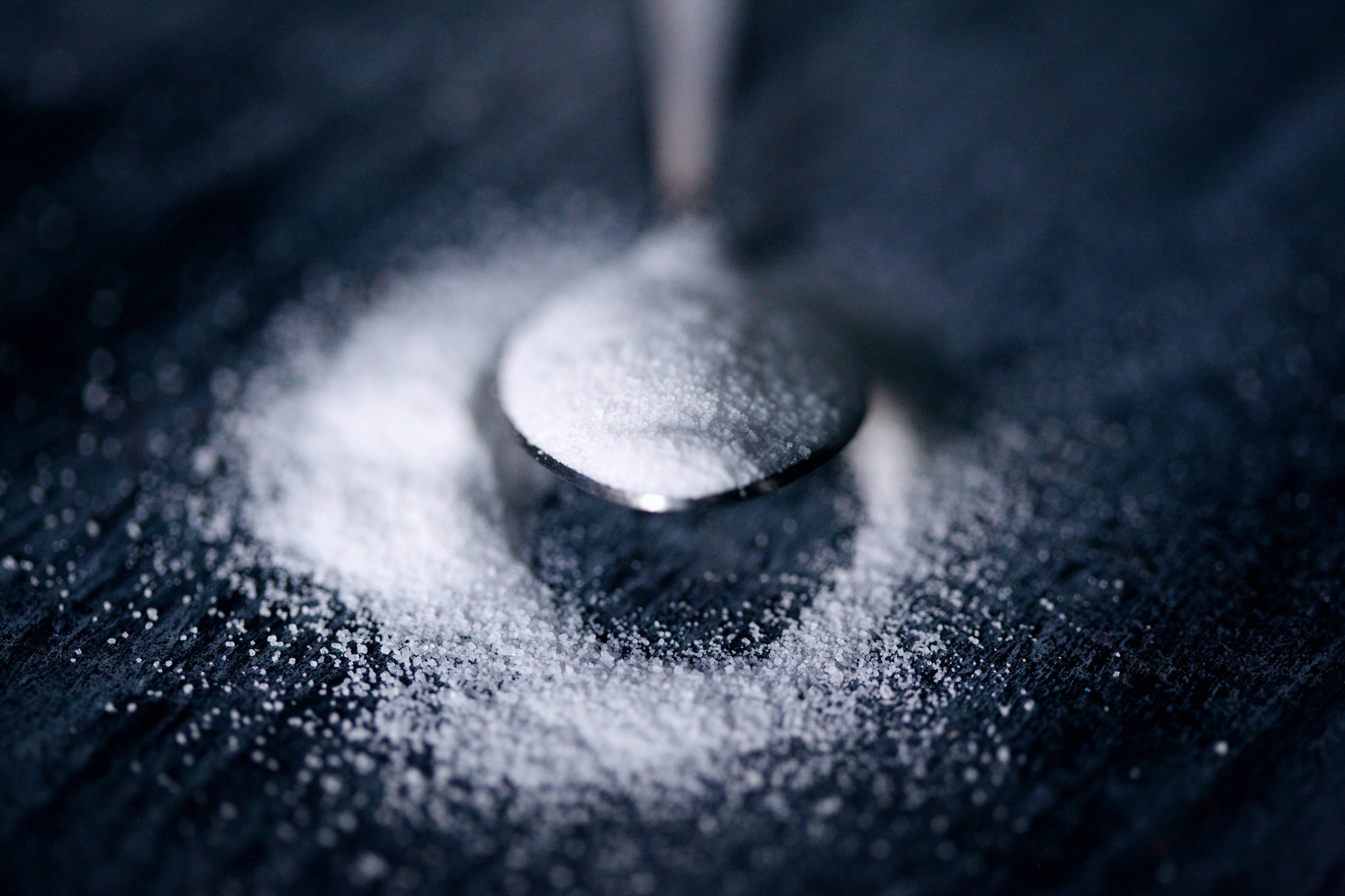 Spoon resting in scattered white sugar