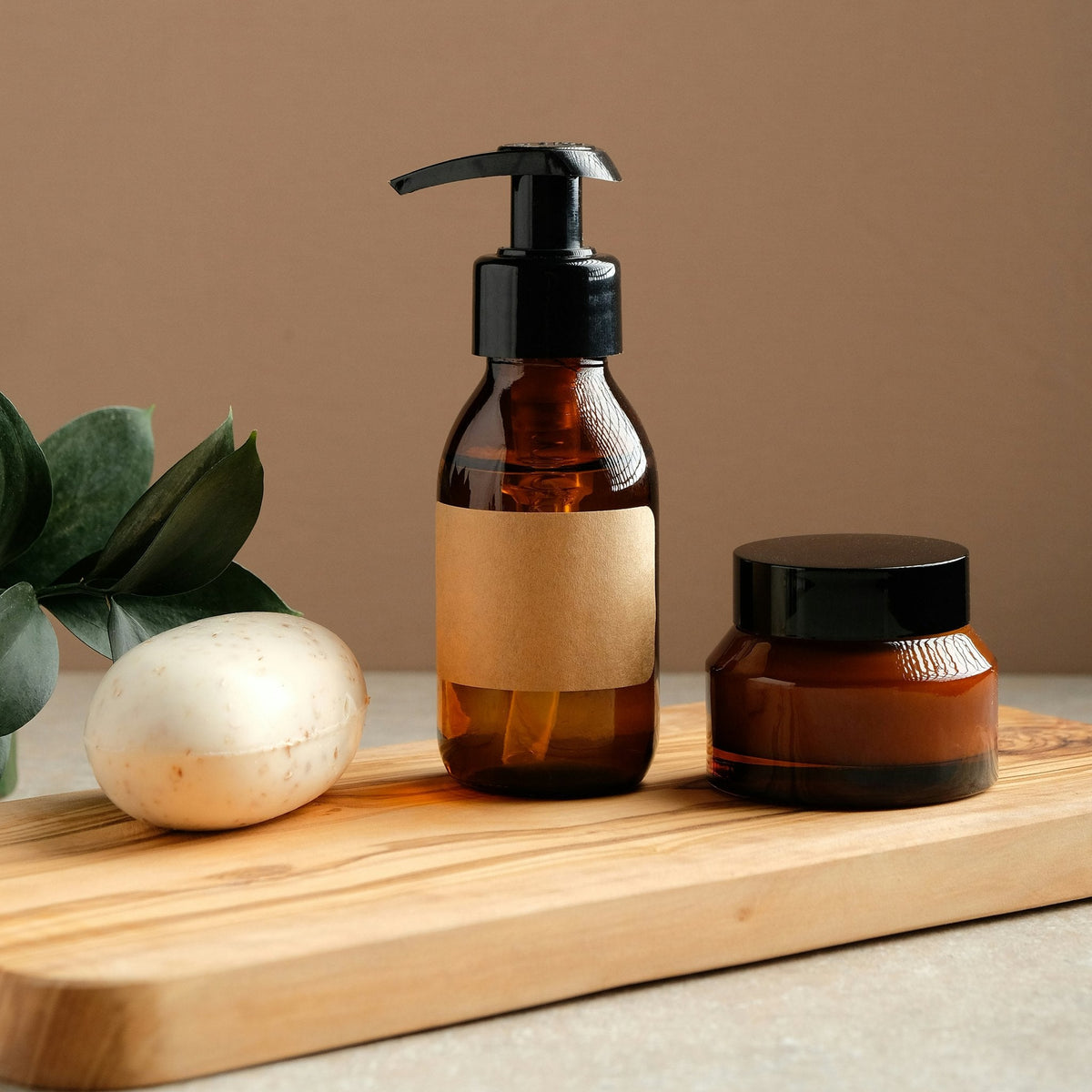 Amber pump bottle and jar on an olive-wood board