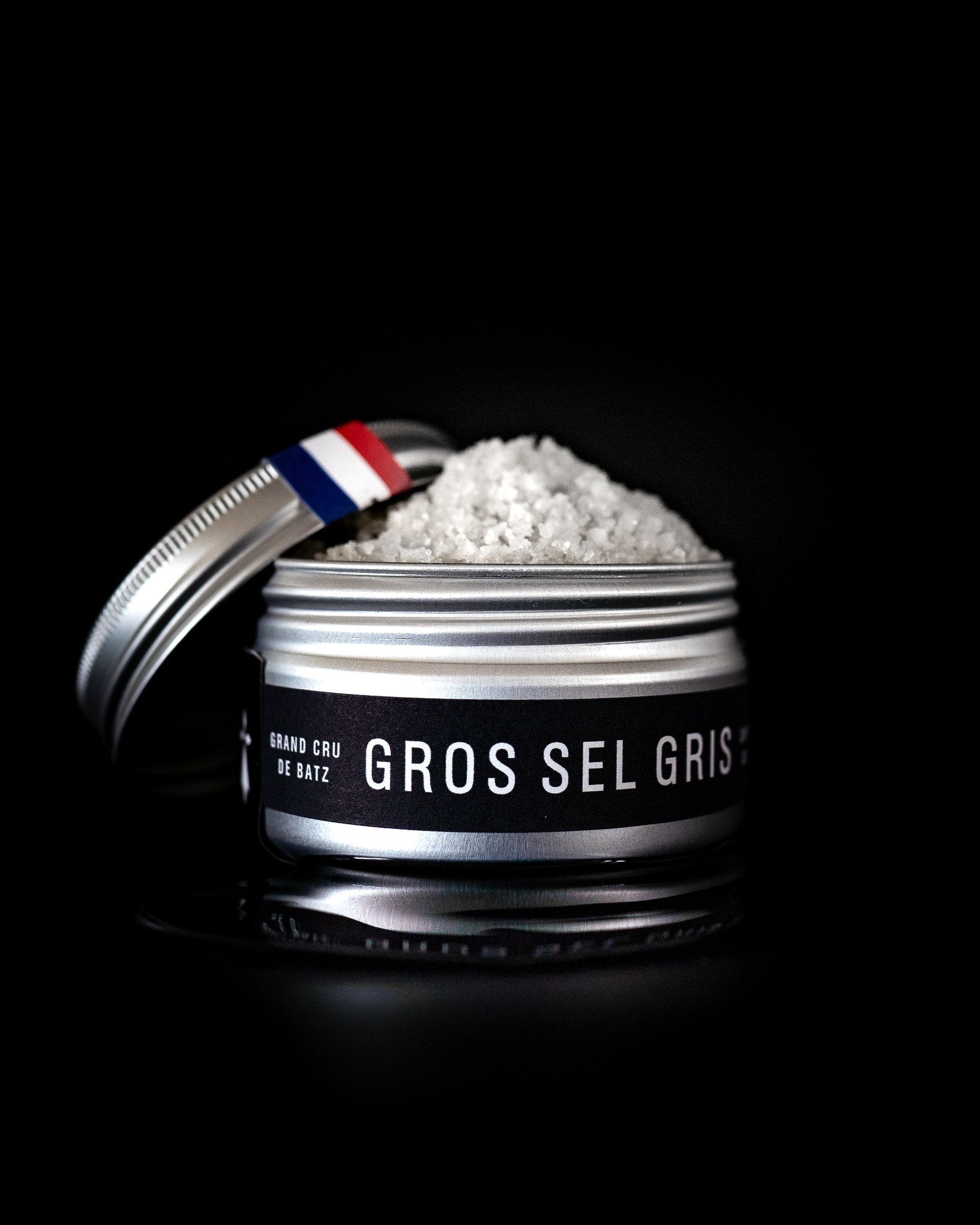 Binet 1660 coarse gray sea salt tin from Batz-sur-Mer on a black background