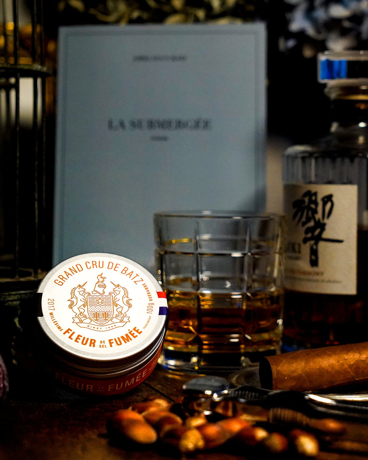Boîte de fleur de sel fumée Binet 1660 à côté d’un verre de whisky