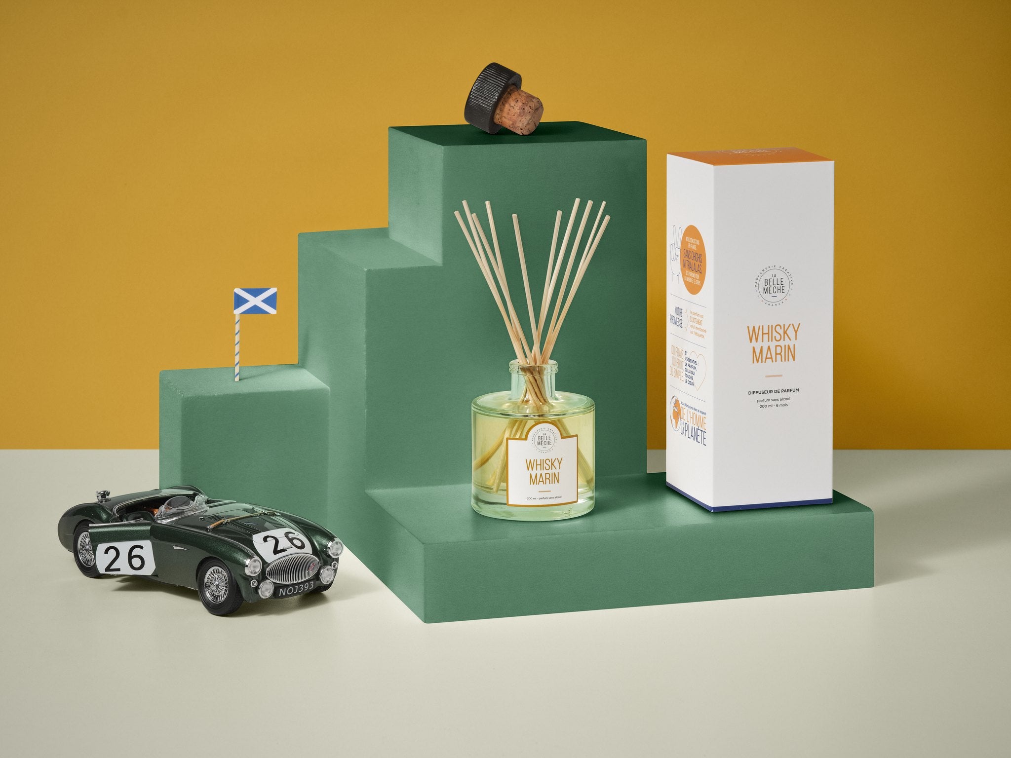 La Belle Mèche Peated Whisky reed diffuser with a vintage racing car