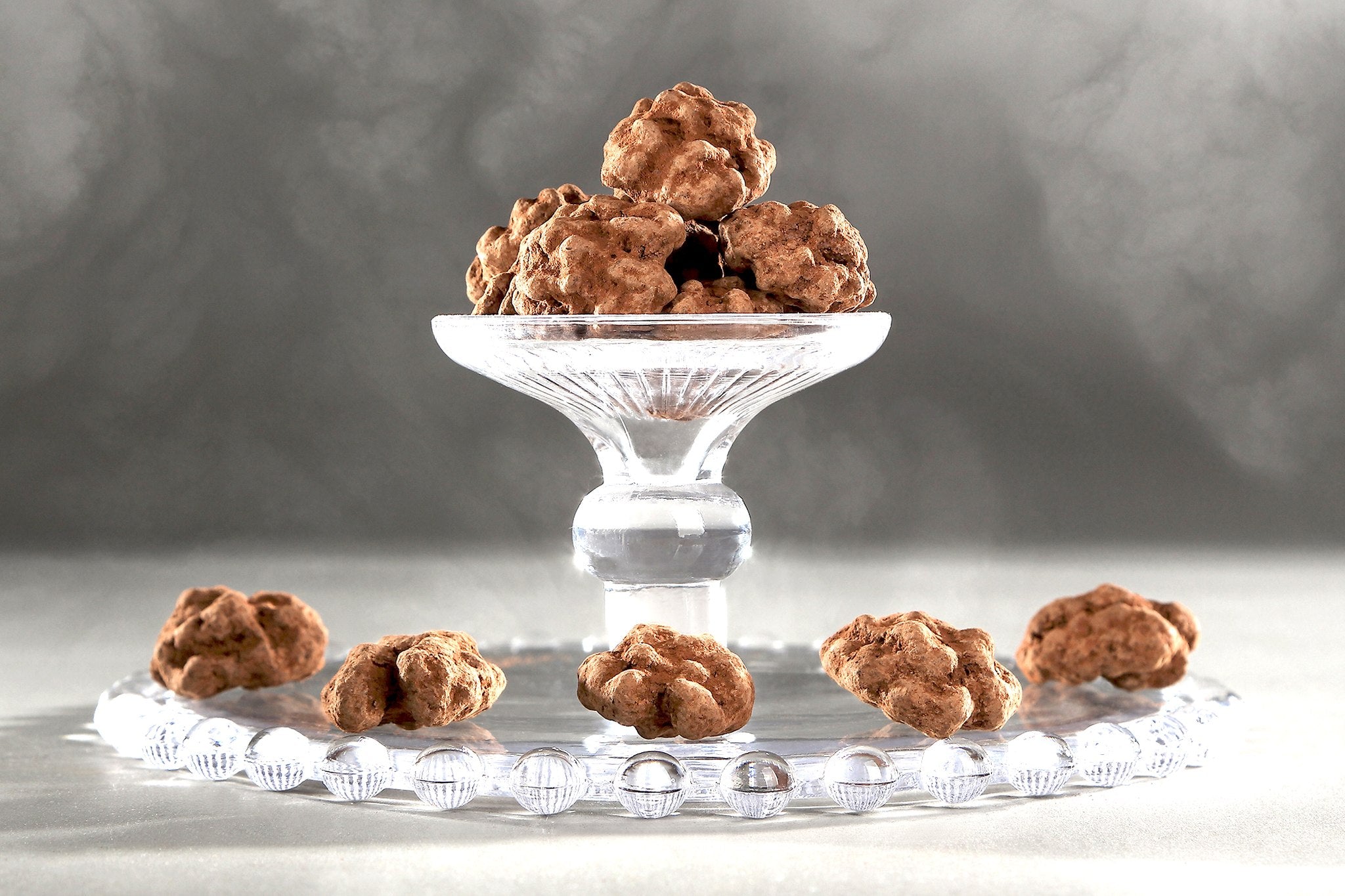 Noix enrobées de chocolat du Domaine de Béquignol servies sur un présentoir à gâteaux en verre