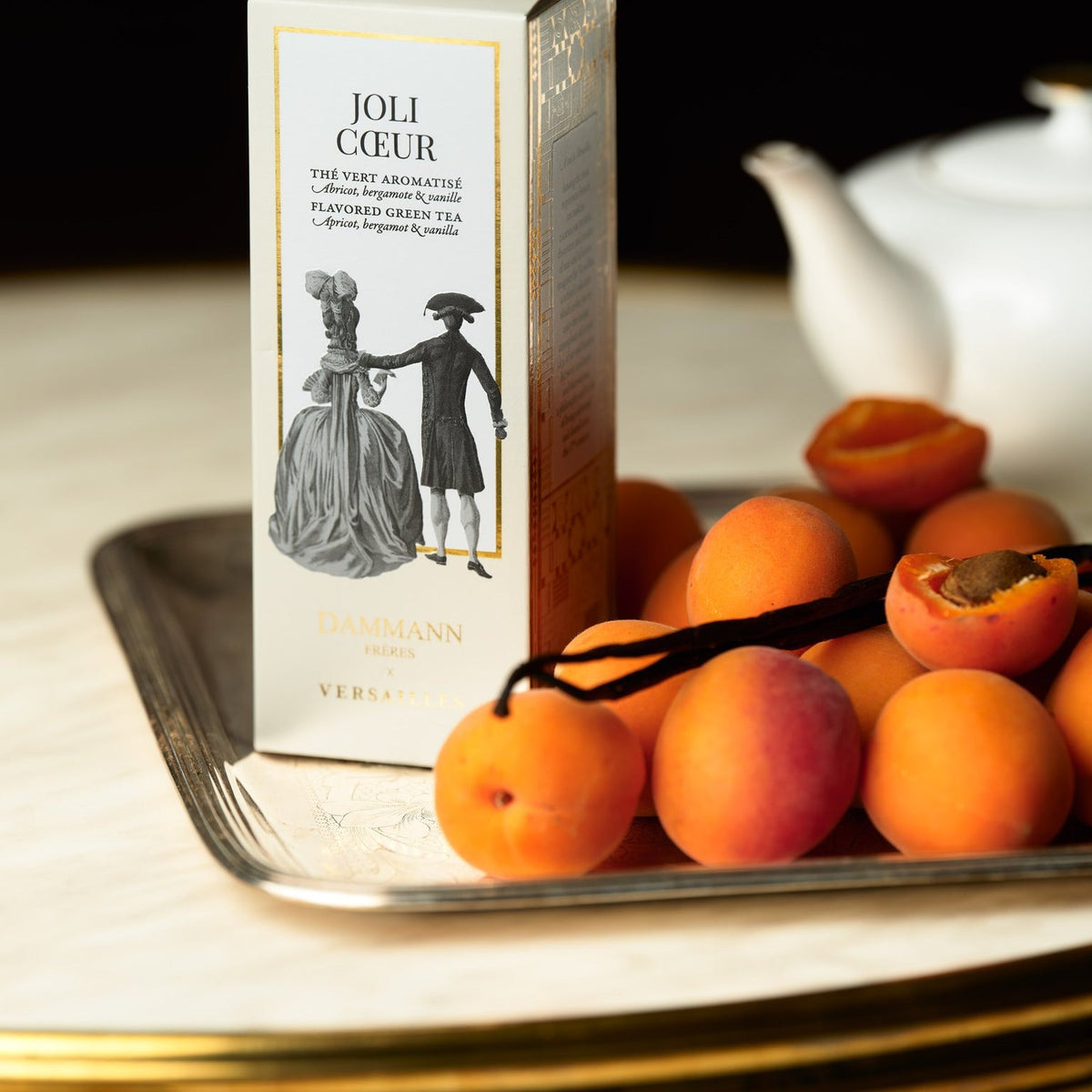 Boîte Joli Cœur de Dammann Frères avec des abricots frais sur un plateau en argent