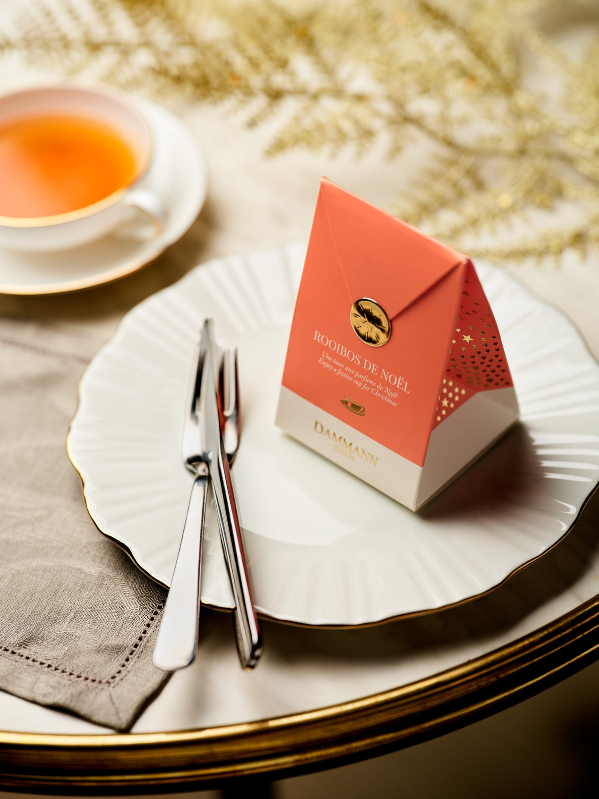 Pochette rose Rooibos de Noël de Dammann Frères sur une table de fête