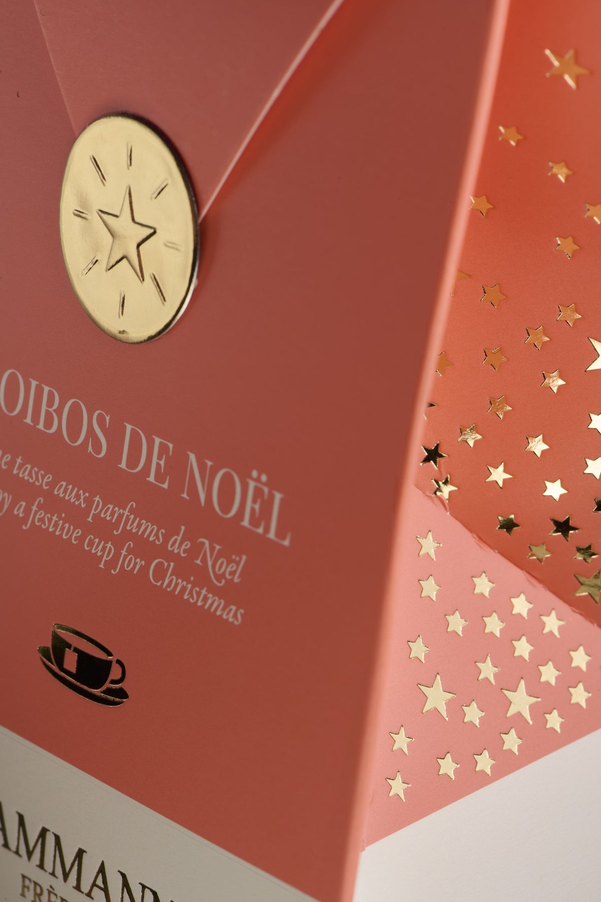 Gros plan sur la pochette rose Rooibos de Noël de Dammann Frères et son sceau doré à l’étoile