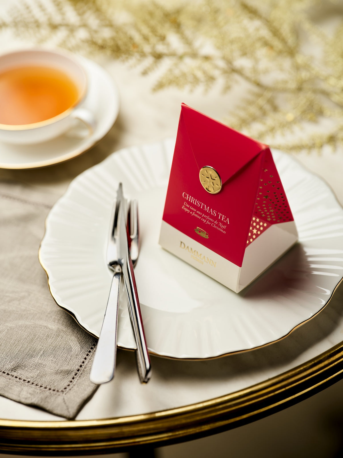 Dammann Frères Christmas Tea red pocket on a festive table setting