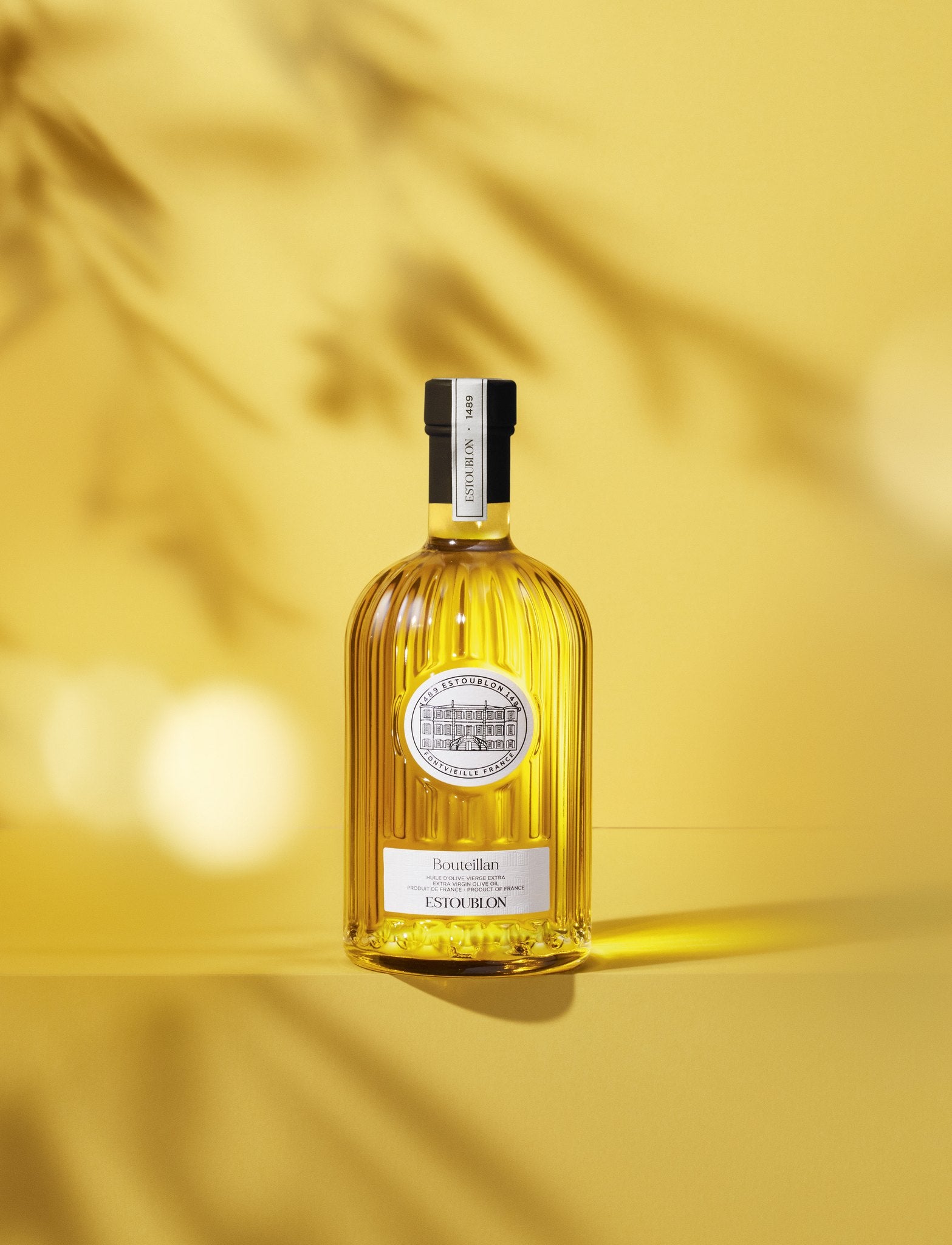 Bouteillan single-variety olive oil by Château d'Estoublon, styled on a yellow background