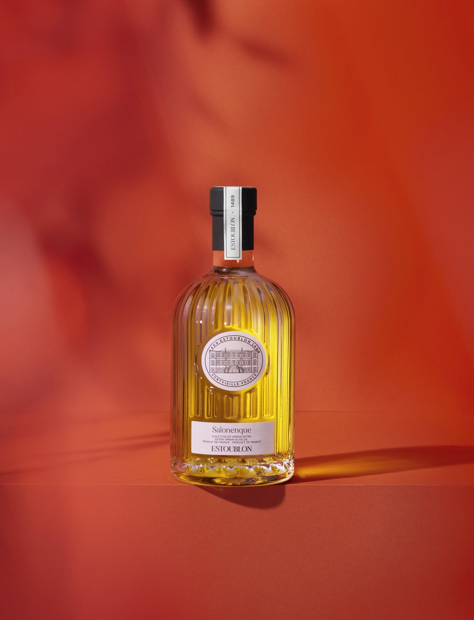 Salonenque single-variety olive oil by Château d'Estoublon, styled on a red background