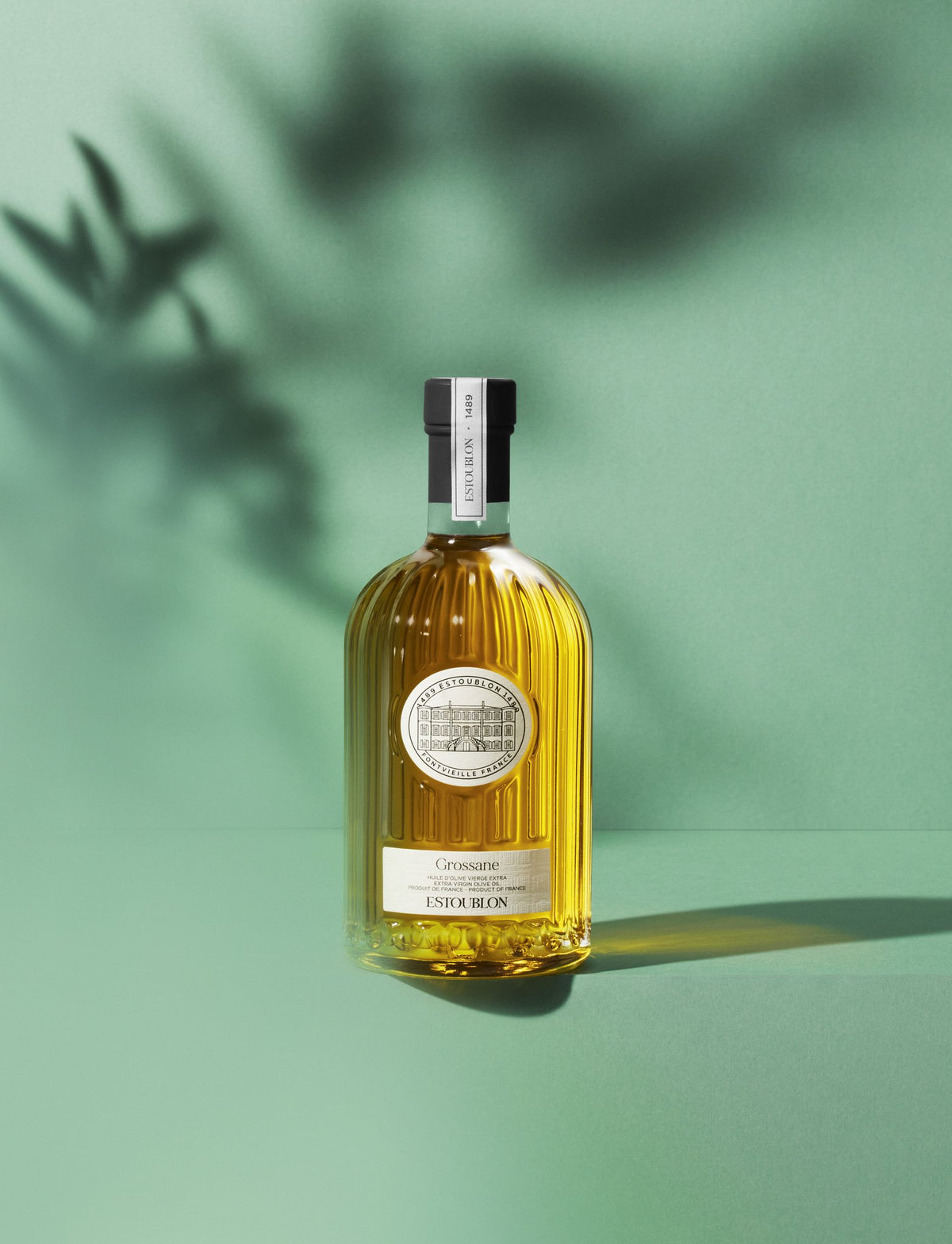 Huile d’olive monovariétale Grossane du Château d’Estoublon, mise en scène sur fond vert