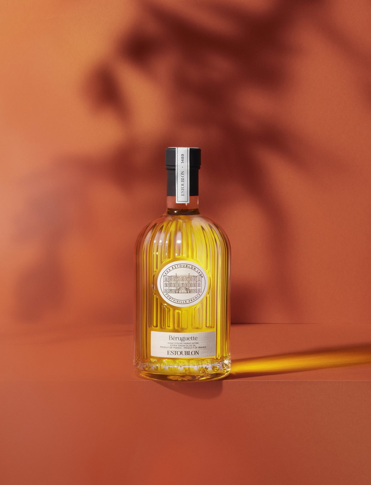 Béruguette single-variety olive oil by Château d'Estoublon, styled on a terracotta background