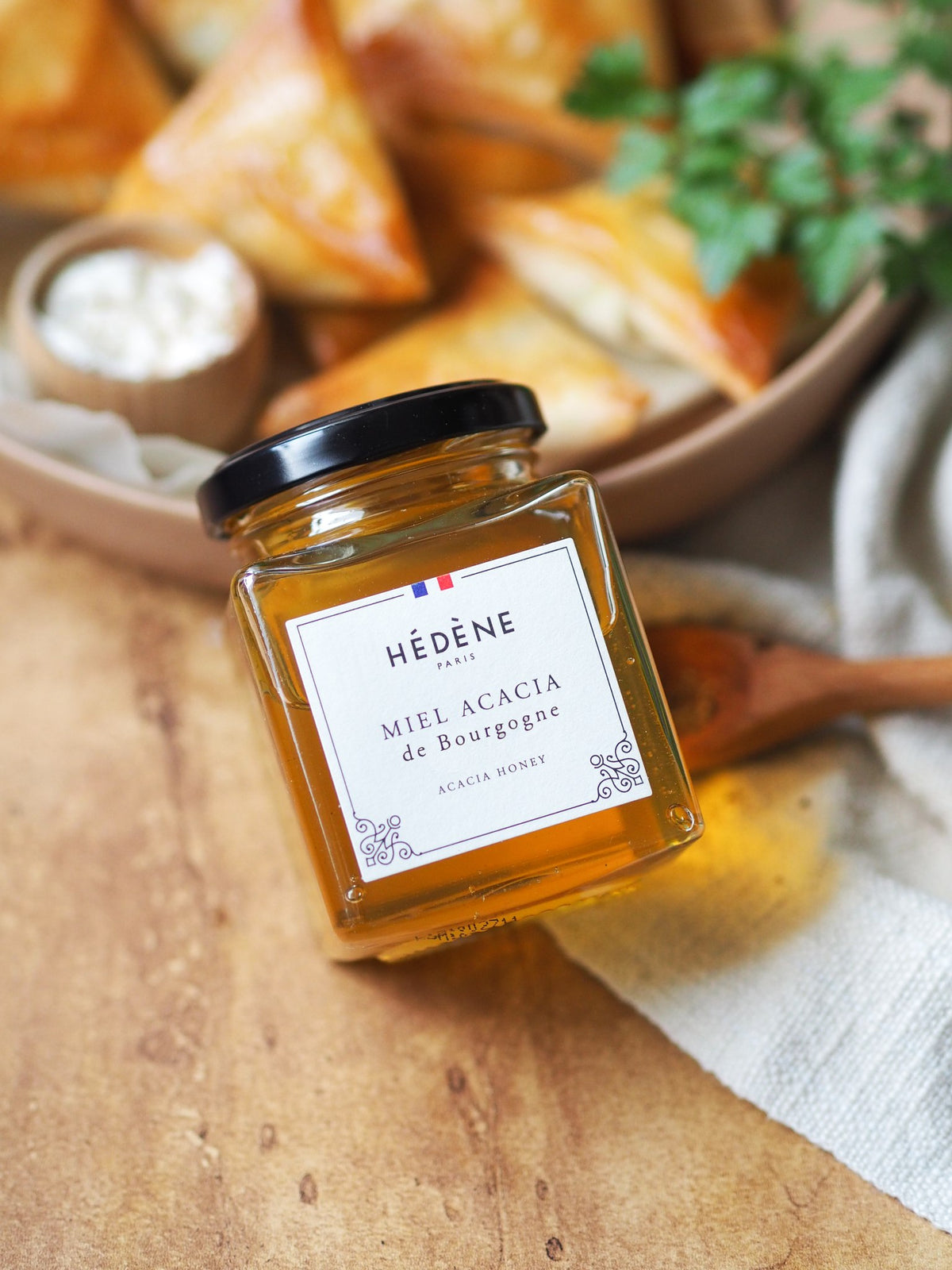 Hédène acacia honey jar on a wooden board with tapas
