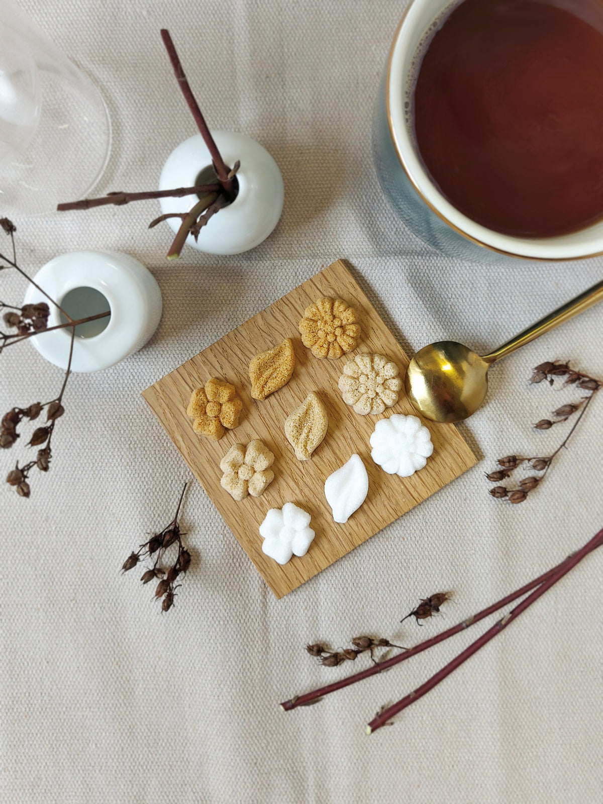Canasuc Bouquet flower-shaped sugars on a wooden board beside a cup of tea