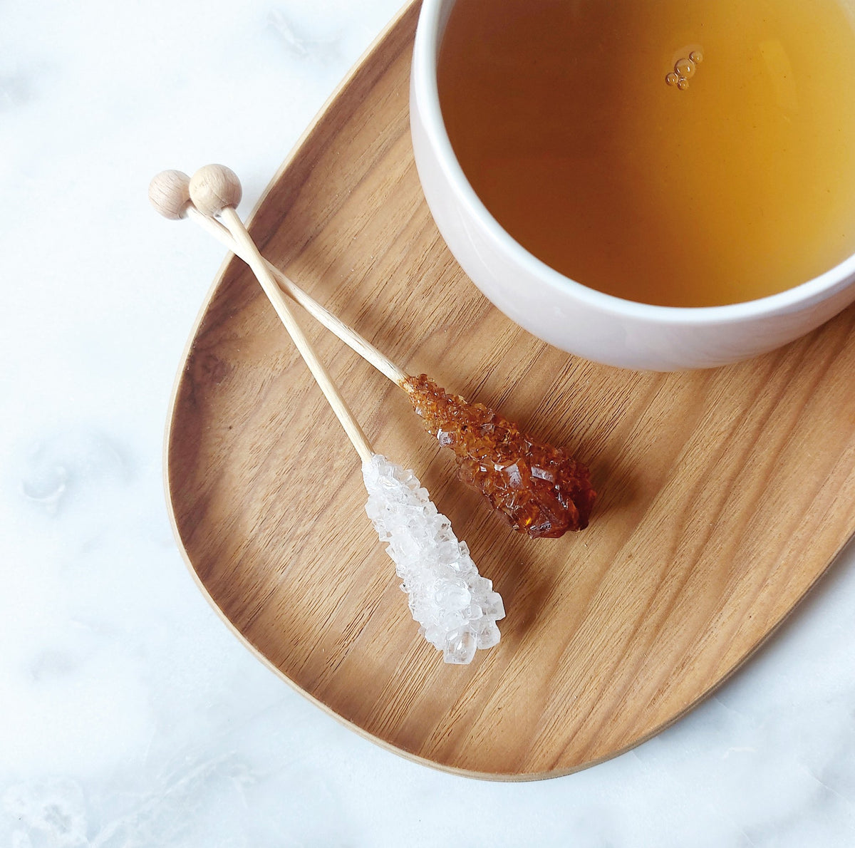 Canasuc amber and white rock candy sticks with a cup of tea