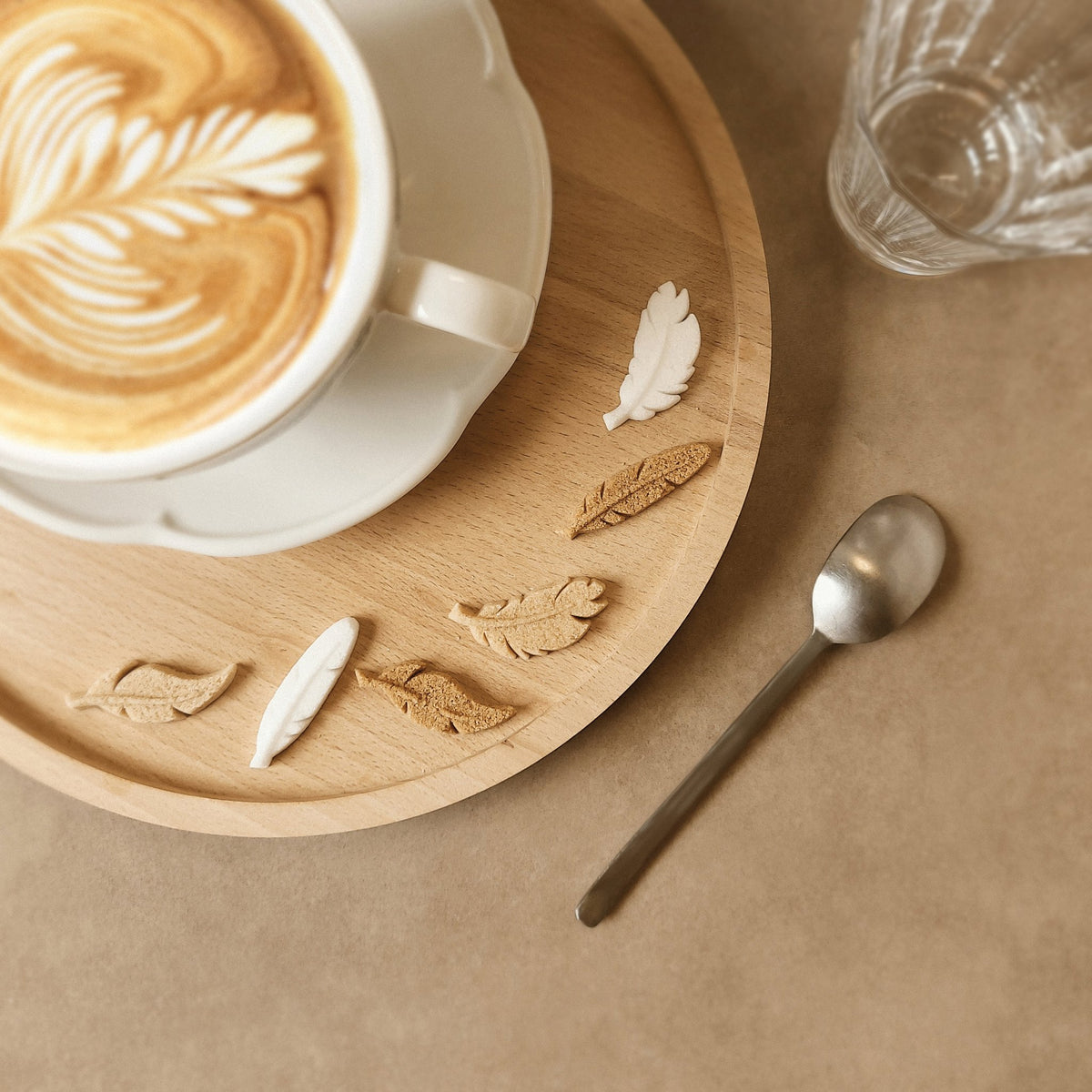 Canasuc L'Air de Rien feather-shaped sugars beside a latte