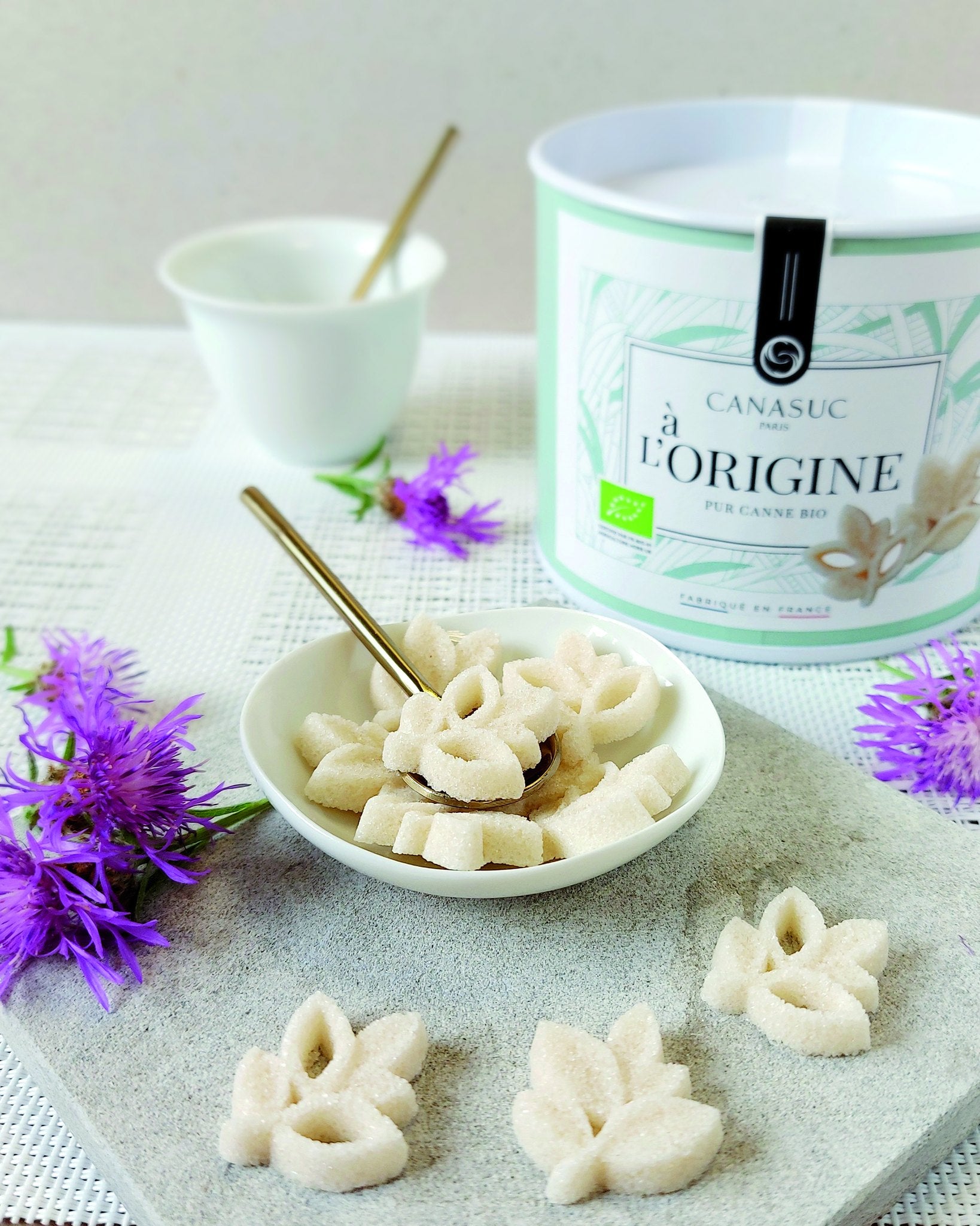 Canasuc À l'Origine organic leaf-shaped sugars in a bowl beside the tin